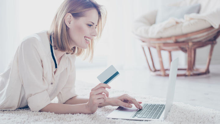 woman laying on ground with credit card