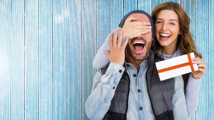 woman surprising man with gift