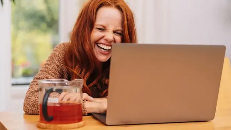woman on laptop laughing
