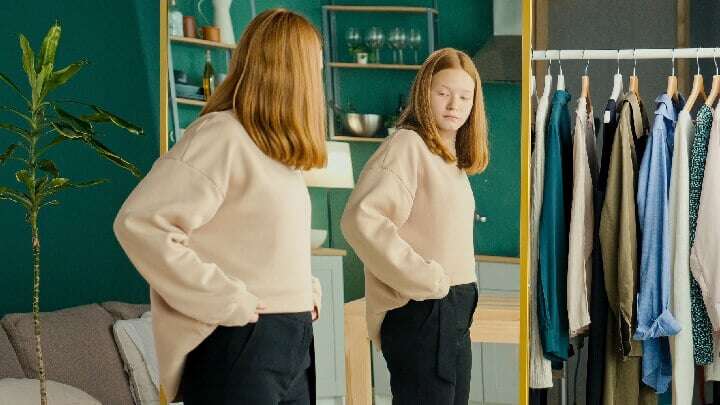 woman trying on new outfit at home