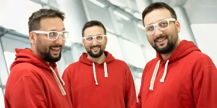 Triplets wearing the same red sweatshirts