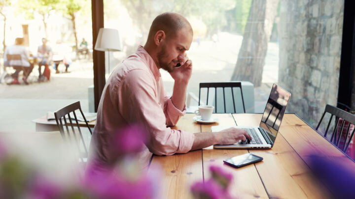 man working on laptop and calling