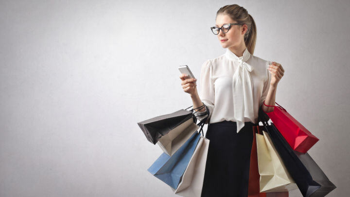 woman texting with shopping bags
